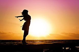 silhouette of woman with hands on air near shore HD wallpaper