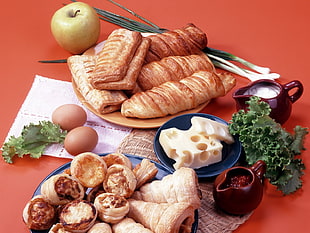 five pastries on ceramic saucer near cheese and apple