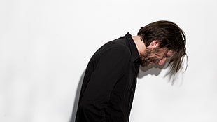 man wearing black collard shirt standing near wall HD wallpaper