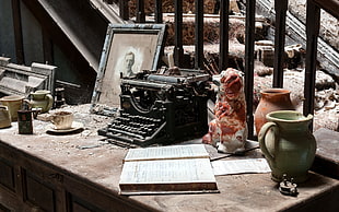 black typewriter near ceramic vases on table