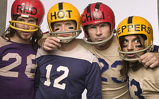four man wearing red and yellow football helmets