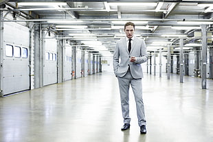 man in grey formal suit standing near sectional door