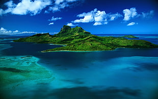 photography of green island with blue sky
