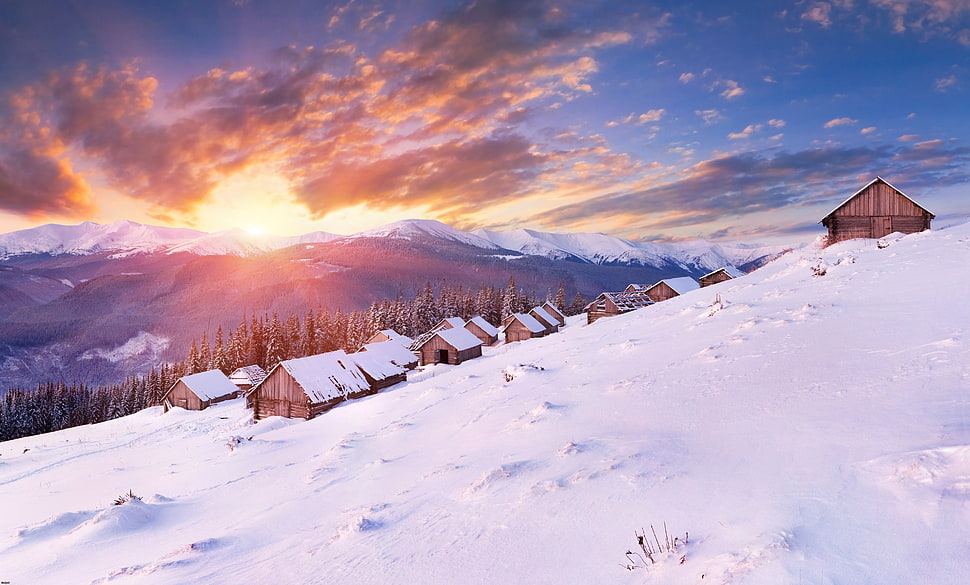 photography of snow covered brown wooden houses during sunrise HD wallpaper