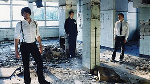 three men stands in concrete building