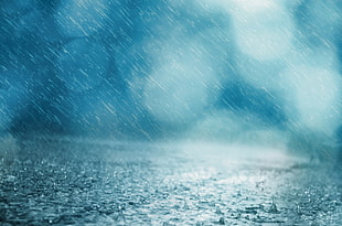 rain pouring on body of water