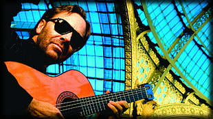 man holding a brown dreadnought classical guitar HD wallpaper