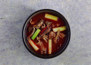 photograph of soup in black ceramic bowl