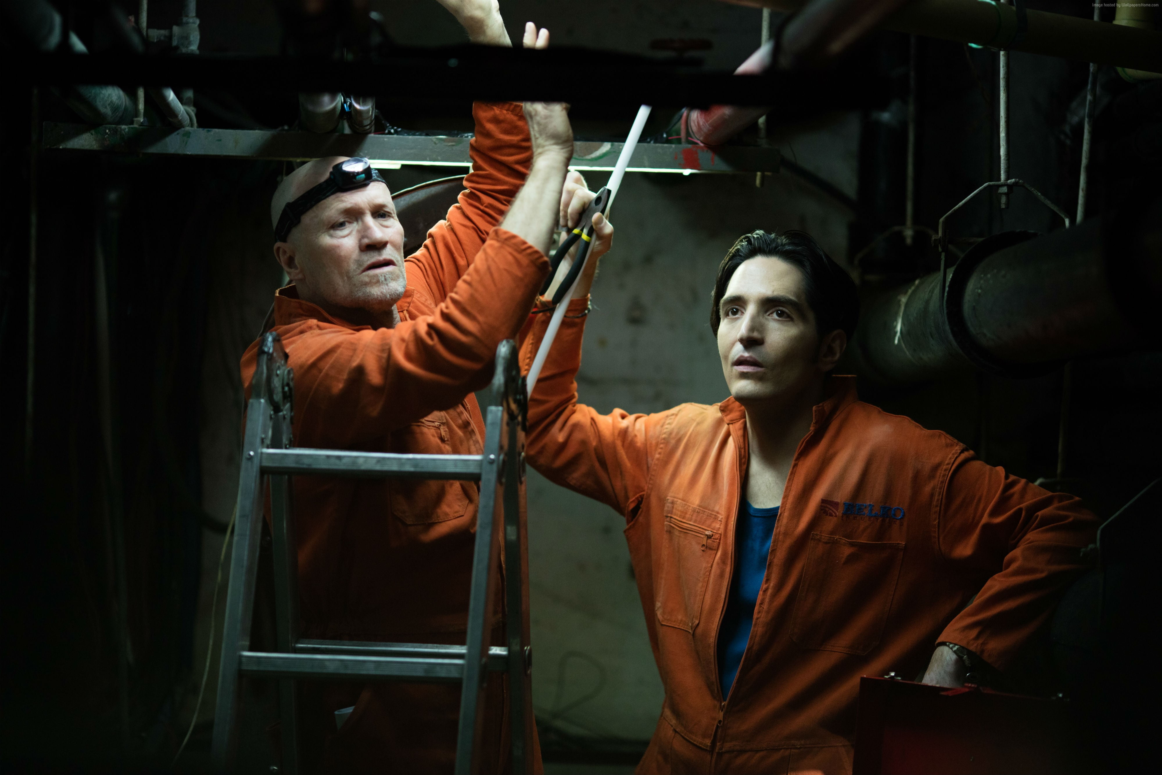 two men in orange working clothes working