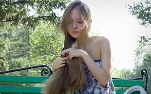 woman in strapless top fixing hair