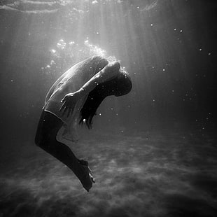 grayscale photo of a woman underwater