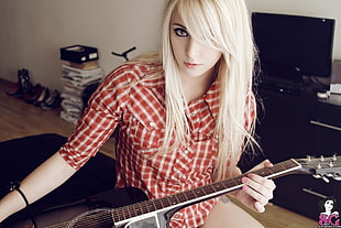 woman holding cutaway acoustic guitar