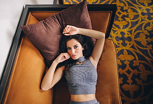 woman wearing grey crop top while lying on couch