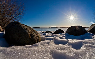 photo of rocks near beach under the sun HD wallpaper
