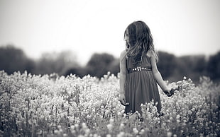 grayscale photography of girl in dress near flowers