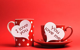 red and white polka dot ceramic mug near teacup with plate