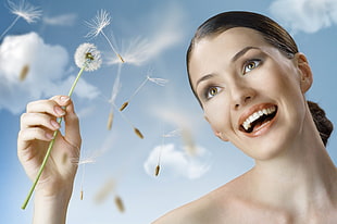woman holding dandelion flower during daytime HD wallpaper