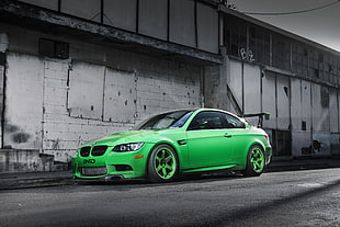 green coupe beside gray building HD wallpaper