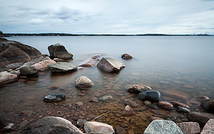 landscape photography of boulders on body of water