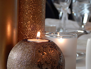votive candle on bowl near candle jars