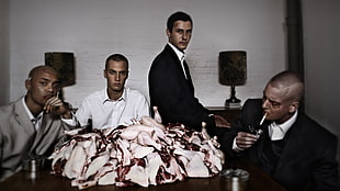 four men wearing formal coats near raw meats