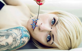 woman lying putting flower on her mouth