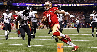 NFL player holding ball running in field HD wallpaper