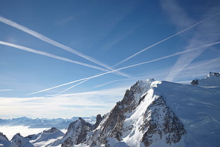 snow mountains with four airplane trails