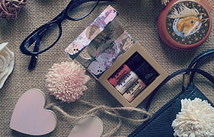 nail polish beside eyeglasses and bag ornament HD wallpaper