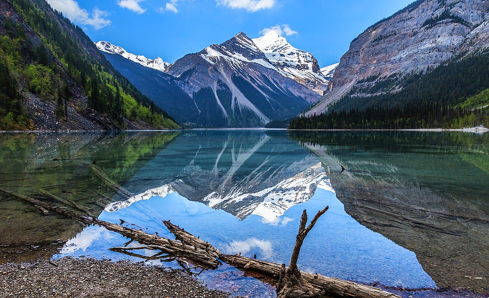 Calm Body Of Lake Water In A Distance Of A Snow Cap Mountain During