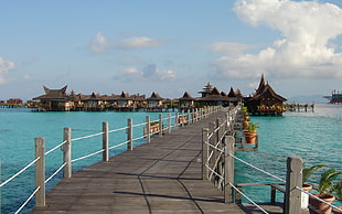 wooden sea dock with wooden canopies on body of water