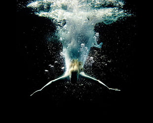underwater photography of person swimming