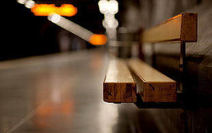 selective focus photo of brown bench with white and orange bokeh