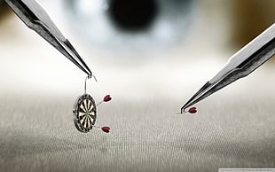 dart board and darts on tweezers