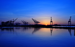 body of water and sun, ports, cranes (machine)