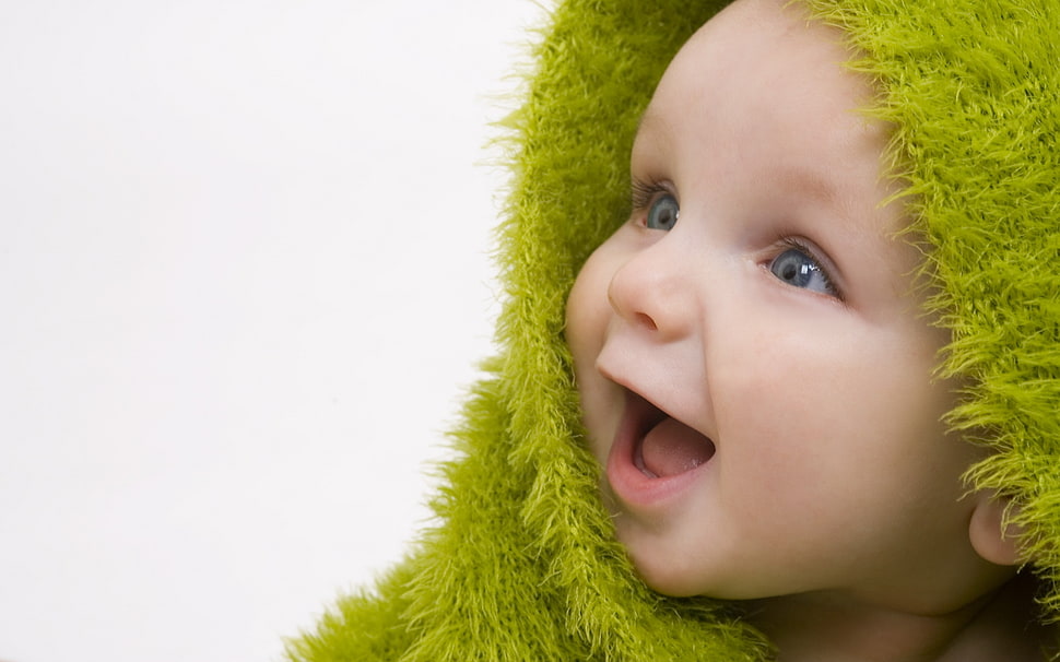 baby in green towel smiling taking portrait HD wallpaper