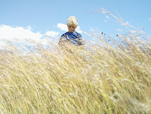 boy standing in the middle of grassland