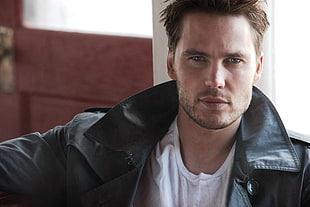 man in black leather collared jacket with white crew-neck shirt