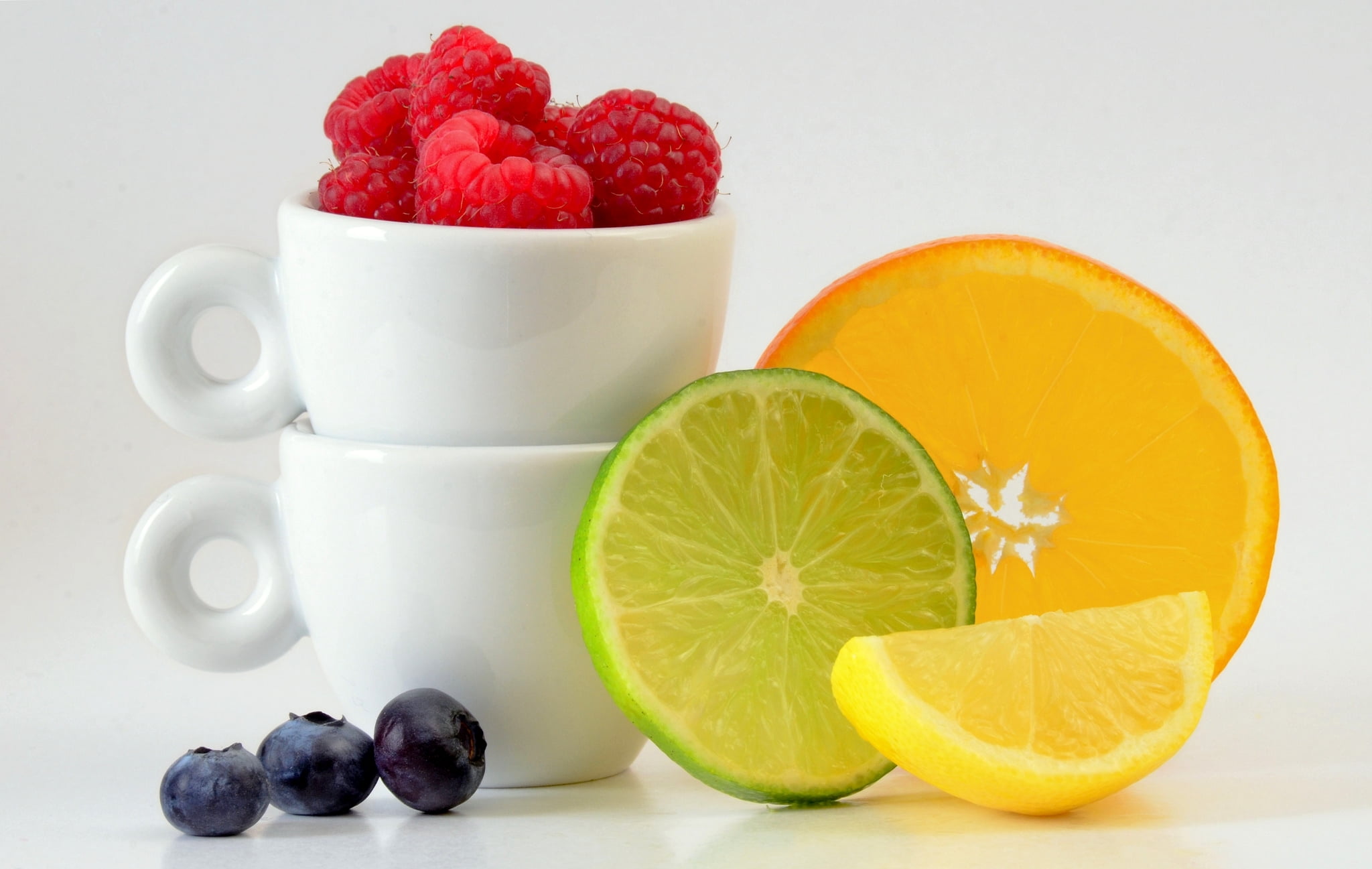 sliced citrus fruits, red raspberries, and blueberries