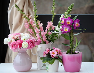 white and pink Roses with pink Primroses and pink Orchids in pot centerpieces
