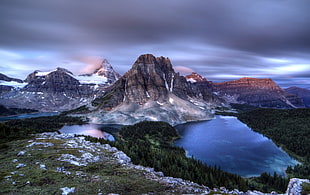 landscape photography of gray mountain near body of water under gray sky