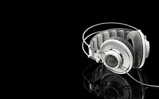 white corded headphone on black glass