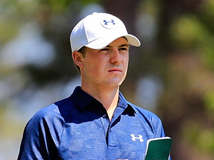 man wearing white Under Armour baseball cap and blue polo shirt