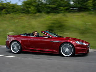 man riding red Aston Martin DB9 Spyder HD wallpaper