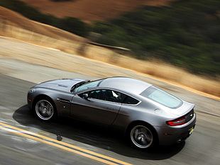 photo of silver Aston Martin coupe along highway