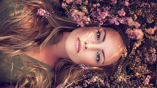 woman beside pink flowers in close up photography