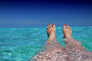 person with red pedicure in water HD wallpaper