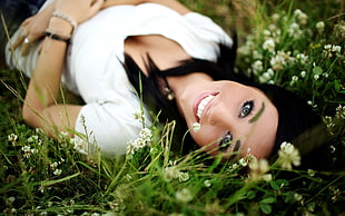 selective focus photography of a woman lying on white petaled flowers
