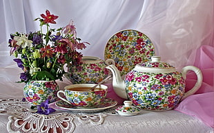 white, pink, green, and orange floral teapot, vase and teacup