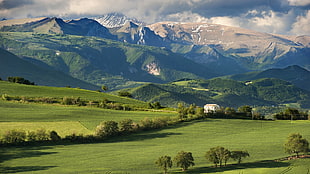 green grass field near mountain, hills, mountains, power lines, trees